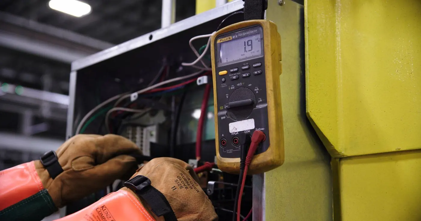 Electrician testing an electrical box with a meter