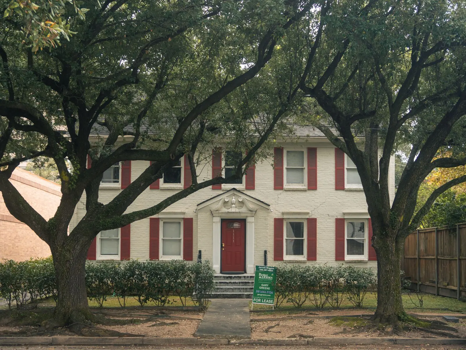 Classic two-story home with shutters and mature trees