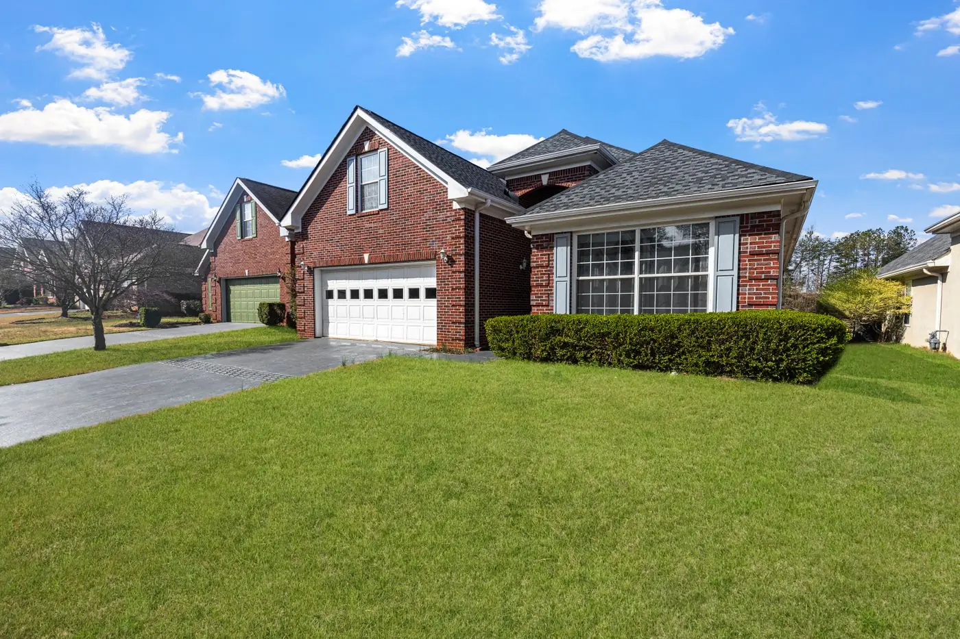 Red brick suburban home with a green front lawn