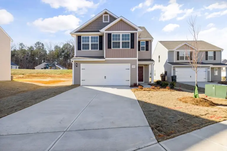 Two-story suburban home with a wide driveway on a sunny day