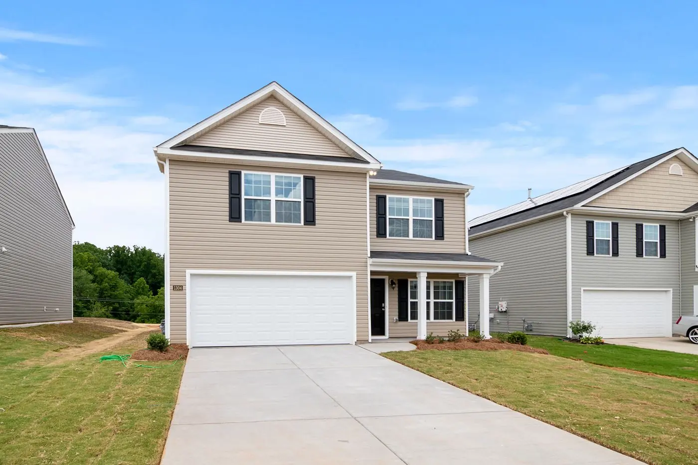 White and gray two-story home under a blue sky